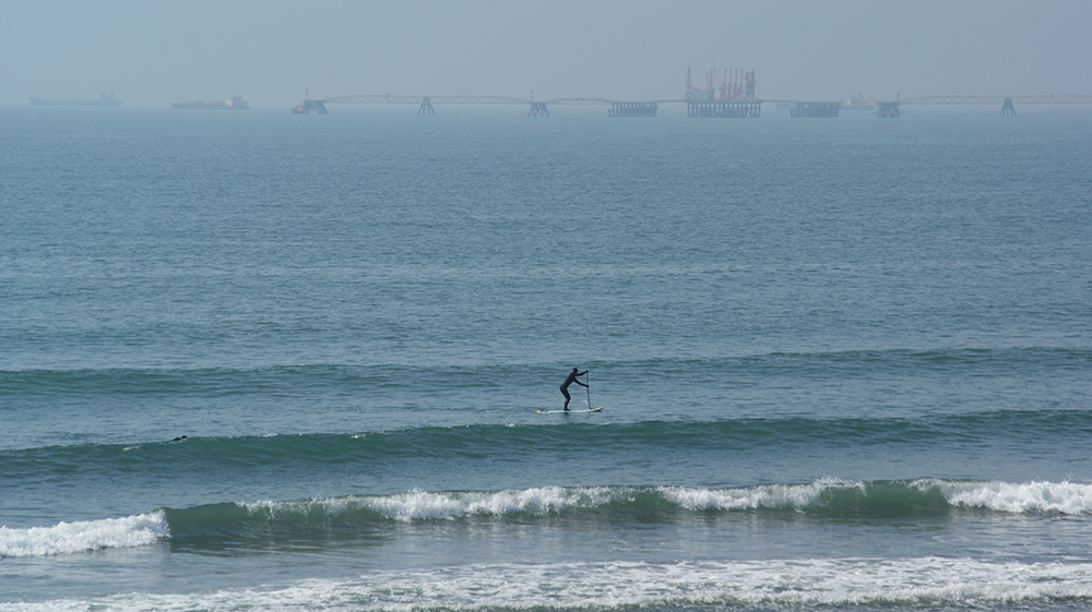 シカッティにて波を追いかけるパートナー写真1